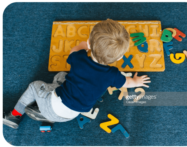 Boy playing with a puzzle on the floor
